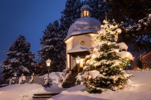 Aufnahme der Stille-Nacht-Kapelle um die Weihnachtszeit mit Christbaum im Schnee